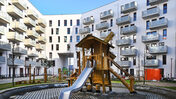 Das Foto zeigt eine Aufnahme vom Hof mit Spielplatz des neuen Hauses der STADT UND LAND in der Pöhlbergstraße.