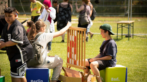 Spielefest Mariendorf 2022, Kinder und Jugendliche spielen ein Holz-Spiel