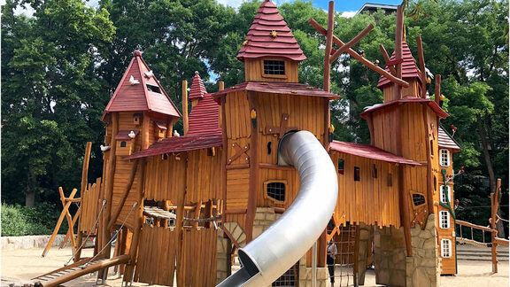 Das Bild zeigt eine Ritterburg zum Kletterburg aus Holz auf einem Spielplatz.